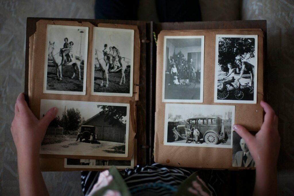 Öppet fotoalbum med svartvita familjebilder från olika decennier